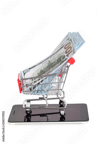 Supermarket trolley and dollars on white background