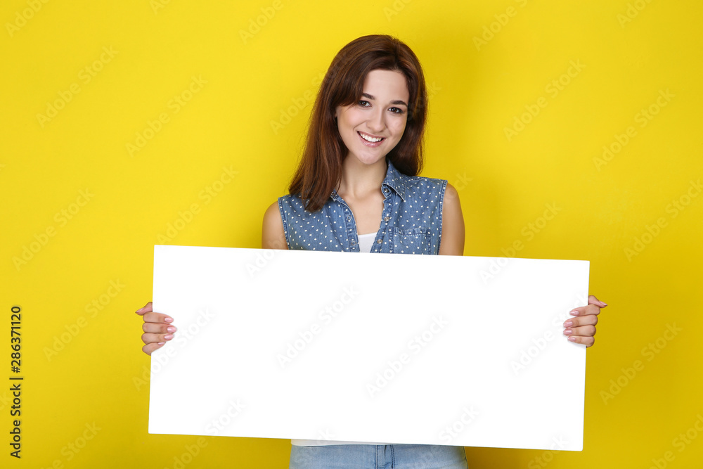 Young woman with blank board on yellow background Young woman with blank board on yellow background