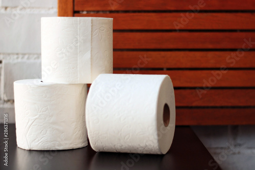 White toilet paper rolls and other home related objects against a white wall. Copy space.