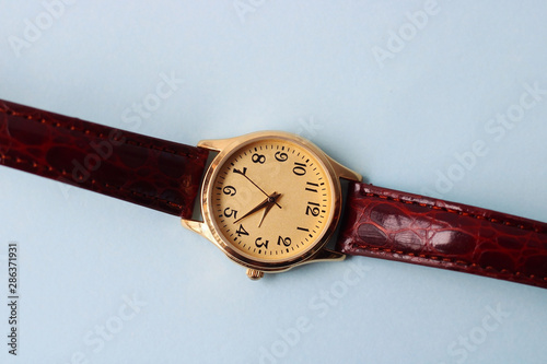 Gold and quartz watch on a blue background.