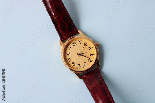 Gold and quartz watch on a blue background.