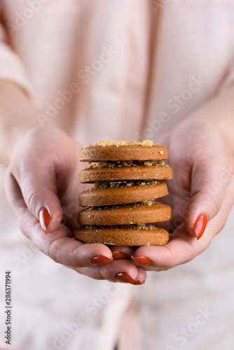 Tasty fragrant cookies with nuts in female hands. Confectioner, homemade cakes.