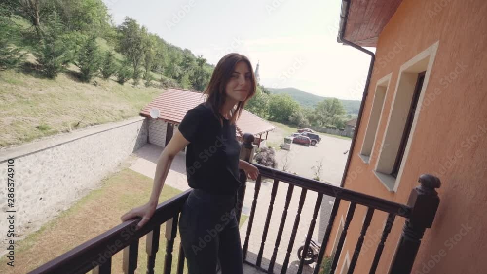 Beautiful young woman relaxing on balcony in mountains. Slow motion