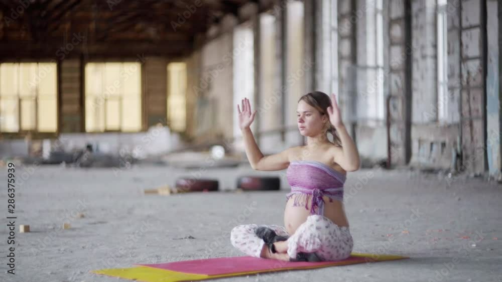 pregnant woman practices yoga in an abandoned building pregnant woman practices yoga in an abandoned building
