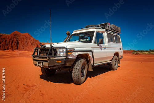 Western Australia – Outback track with 4WD car on red sand at the ocean at Dampier Peninsula photo