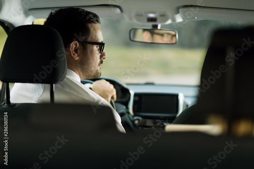Rear view of a businessman driving a car © Goran