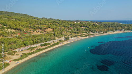 Aerial drone view of iconic sandy turquoise organised with sun beds and umbrellas beach of Paliouri in Kassandra Peninsula, Halkidiki, North Greece © aerial-drone