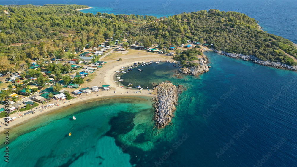 Aerial drone view of iconic sandy turquoise organised with sun beds and umbrellas beach of Paliouri in Kassandra Peninsula, Halkidiki, North Greece