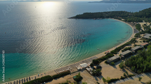 Aerial drone view of iconic sandy turquoise organised with sun beds and umbrellas beach of Paliouri in Kassandra Peninsula, Halkidiki, North Greece