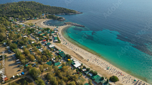 Aerial drone view of iconic sandy turquoise organised with sun beds and umbrellas beach of Paliouri in Kassandra Peninsula, Halkidiki, North Greece photo