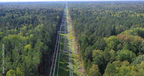 Tower of power lines in the forest. Electric tower line in Landscape view with Electricity and environmental problem concept. Ariel view High voltage power pylons.