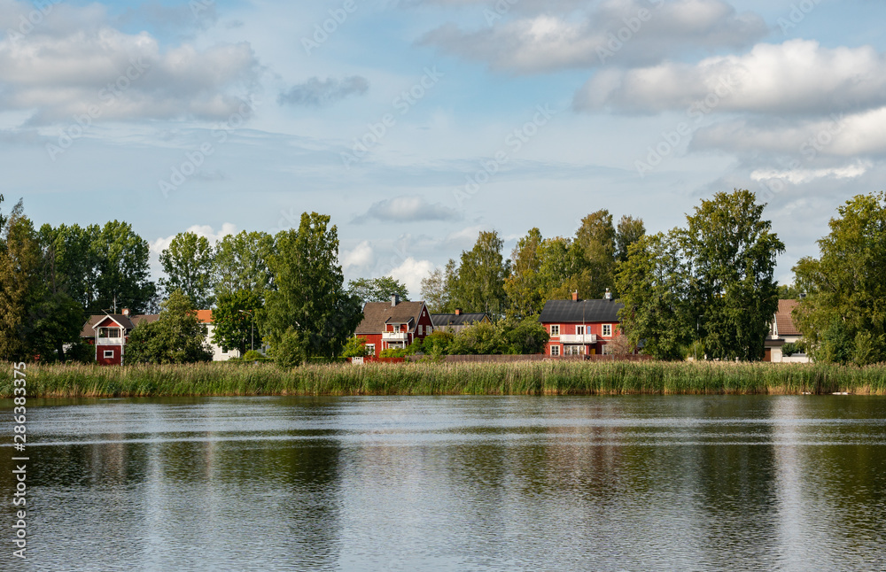Obraz premium idyllic view in Karlstad Sweden. traditional houses next to the river sourrounded by the green nature
