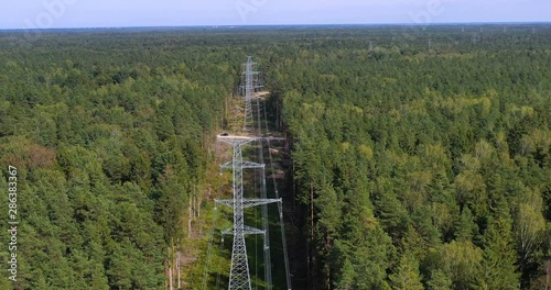 Tower of power lines in the forest. Electric tower line in Landscape view with Electricity and environmental problem concept. Ariel view High voltage power pylons.