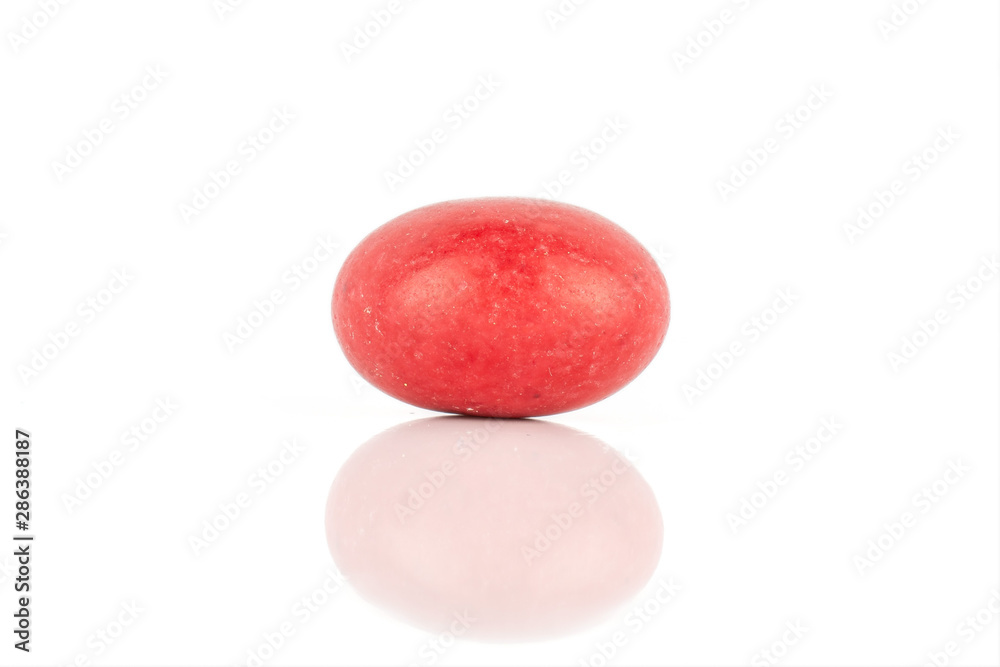 One whole red sugared nut dragee isolated on white background One whole red sugared nut dragee isolated on white background