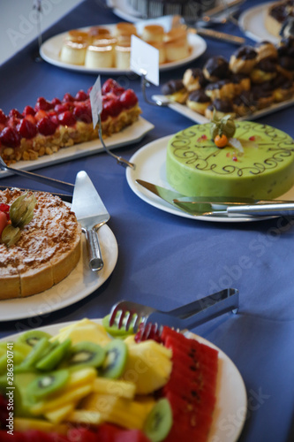 An assortment of desserts on the buffet table - fresh fruits  cakes  tarts and custard dessert