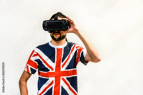 Man on white background with Virtual Reality headsets on, experimenting and testing new VR technology. Man with 4K Glasses watching games or videos.