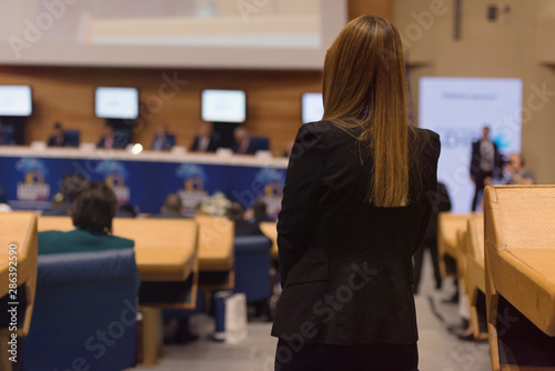 Business woman representing model of economic development and startup business, woman as a leader. Audience at the conference hall, Business Conference and Presentation.