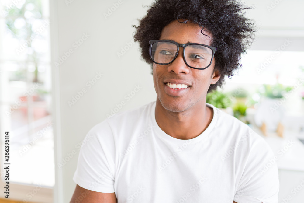 Fototapeta premium African American man wearing glasses smiling looking side and staring away thinking.