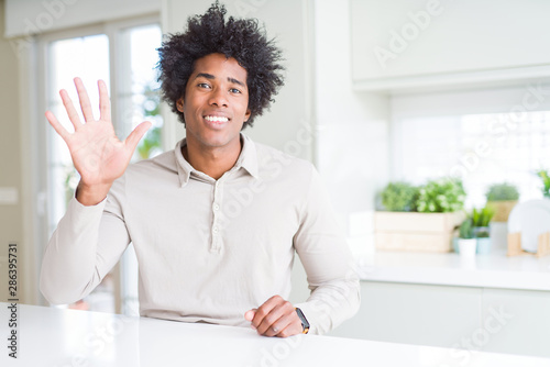 African American man at home showing and pointing up with fingers number five while smiling confident and happy.