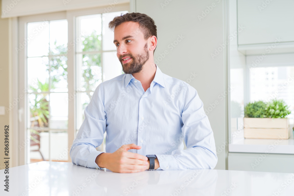 Handsome business man looking away to side with smile on face, natural expression. Laughing confident.