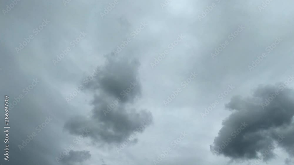 Moody, grey clouds moving against a dark sky overhead Moody, grey clouds moving against a dark sky overhead