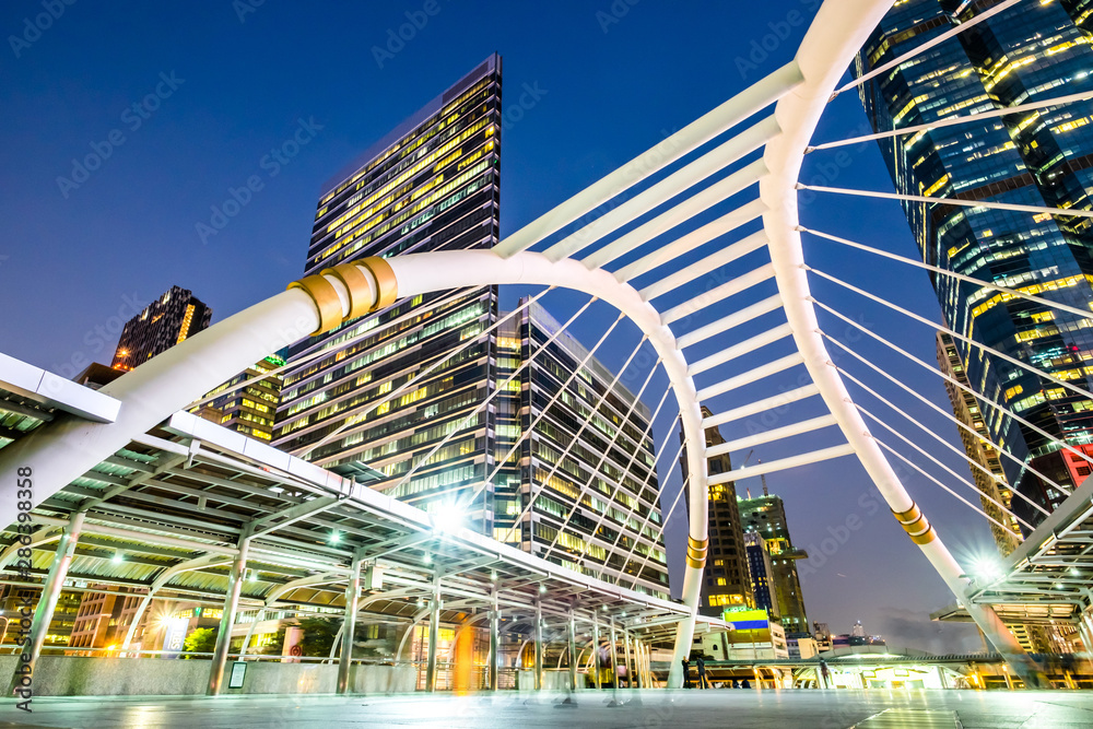 Naklejka premium public skywalk at bangkok downtown square night in business zone