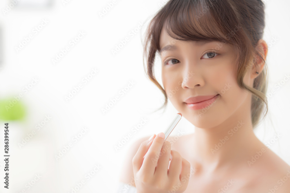 Beautiful portrait young asian woman applying makeup lipstick in the room, beauty lips asia girl makeup and cosmetic fashion on mouth at home, lifestyle and health care concept. Beautiful portrait young asian woman applying makeup lipstick in the room, beauty lips asia girl makeup and cosmetic fashion on mouth at home, lifestyle and health care concept.
