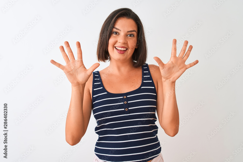 Young beautiful woman wearing blue striped t-shirt standing over isolated white background showing and pointing up with fingers number ten while smiling confident and happy. Young beautiful woman wearing blue striped t-shirt standing over isolated white background showing and pointing up with fingers number ten while smiling confident and happy.