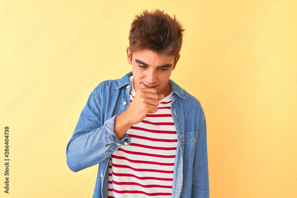 Young handsome man wearing striped t-shirt and denim shirt over isolated yellow background feeling unwell and coughing as symptom for cold or bronchitis. Healthcare concept. Young handsome man wearing striped t-shirt and denim shirt over isolated yellow background feeling unwell and coughing as symptom for cold or bronchitis. Healthcare concept.