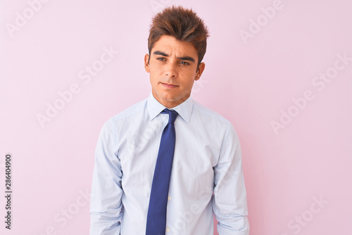 Young handsome businessman wearing shirt and tie standing over isolated pink background depressed and worry for distress, crying angry and afraid. Sad expression.