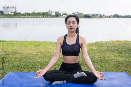 Young beautiful woman practices yoga and meditates outdoor at the mountain. Female doing yoga and meditate to relax and release stress. © EduLife Photos