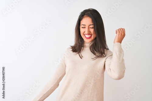 Beautiful chinese woman wearing turtleneck sweater standing over isolated white background Dancing happy and cheerful  smiling moving casual and confident listening to music