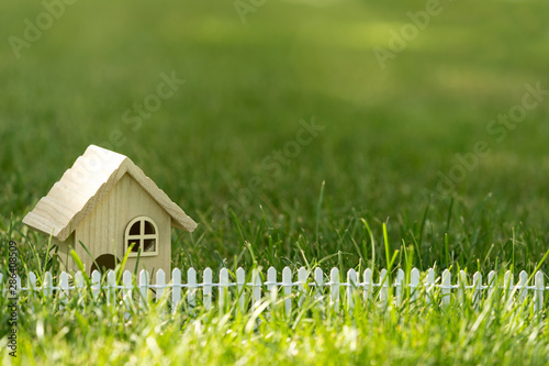 Little house on green grass field in sun light for real estate property