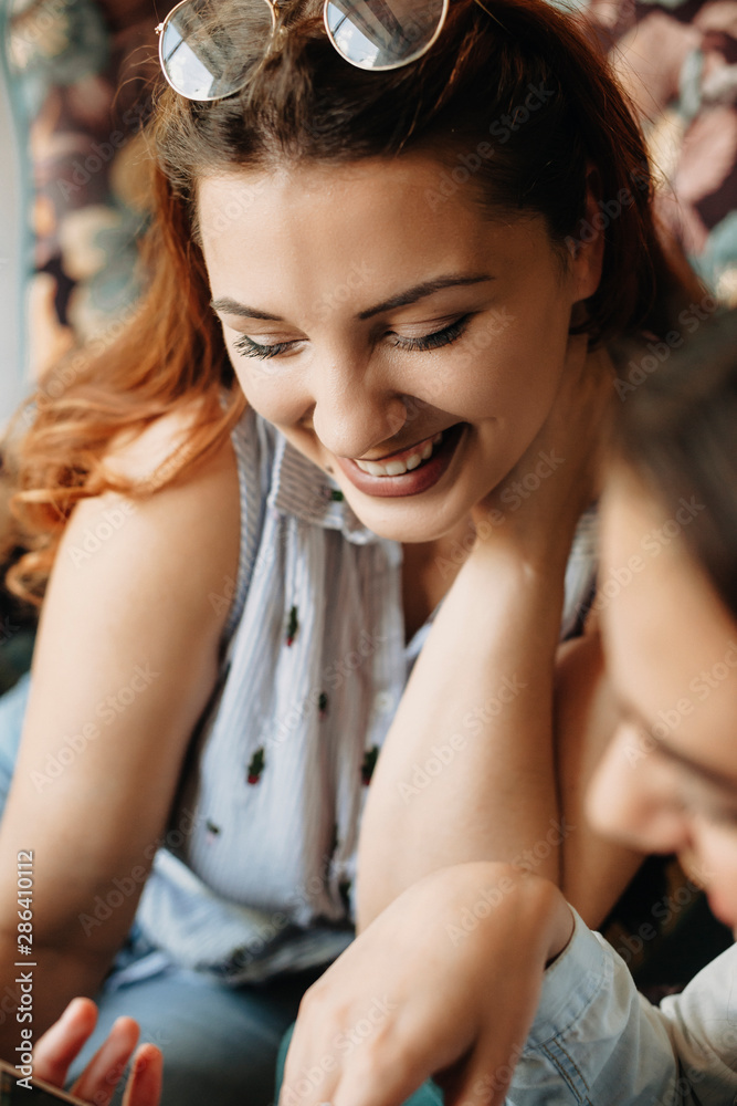 Beautiful red hair woman laughing with closed eyes while sitting in a cafe. Beautiful red hair woman laughing with closed eyes while sitting in a cafe.