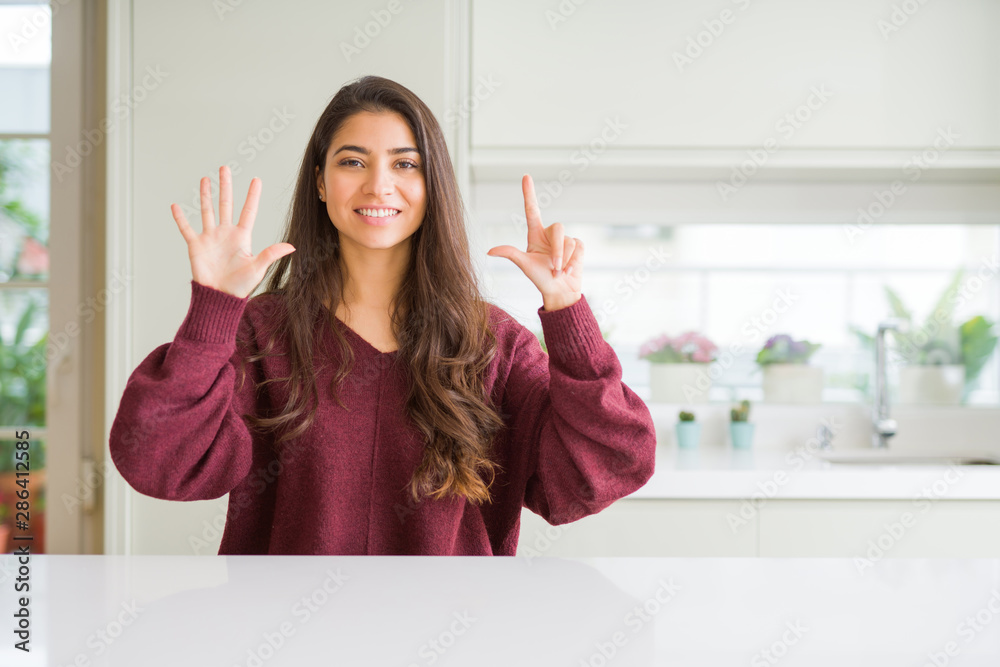 Young beautiful woman at home showing and pointing up with fingers number seven while smiling confident and happy. Young beautiful woman at home showing and pointing up with fingers number seven while smiling confident and happy.