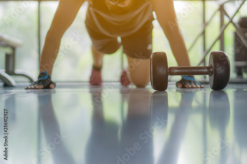 Close up men hand doing push up exercise in the gym in morning sunlight effect. sport, fitness, health, lifestyle and people concept