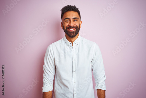 Young indian businessman wearing elegant shirt standing over isolated pink background with a happy and cool smile on face. Lucky person.