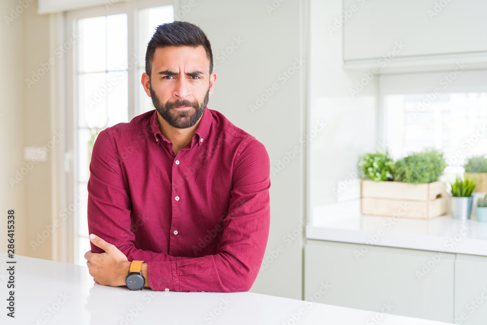 Handsome hispanic business man skeptic and nervous, disapproving expression on face with crossed arms. Negative person. Handsome hispanic business man skeptic and nervous, disapproving expression on face with crossed arms. Negative person.