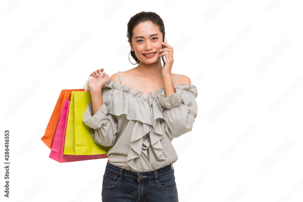 Asian woman carry paper bags and uses smartphone.. Asian woman carry paper bags and uses smartphone..