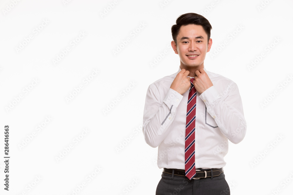 Young Asian businessman is manage his shirt.. Young Asian businessman is manage his shirt..