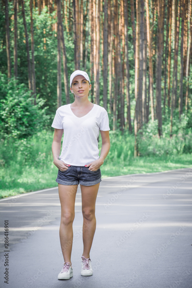Beautiful young girl walks in a pine forest