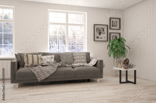Stylish room in white color with sofa and winter landscape in window. Scandinavian interior design. 3D illustration © AntonSh