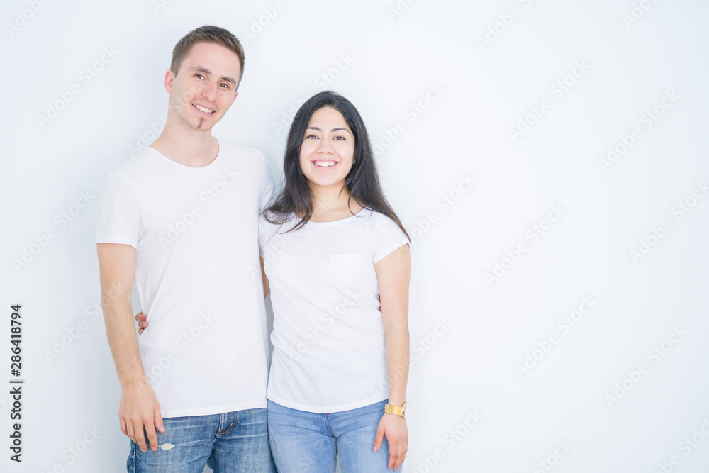 Young beautiful couple wearing casual t-shirt standing over isolated white background with a happy and cool smile on face. Lucky person. Young beautiful couple wearing casual t-shirt standing over isolated white background with a happy and cool smile on face. Lucky person.