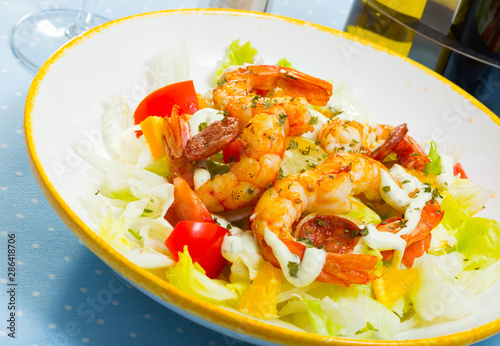 Seafood salad with shrimps, lettuce leaf, tomatoes and lemon