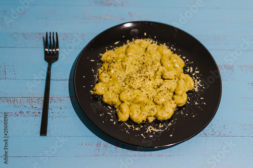 creamy gnocchi with parmesan and herbs served on teal plate