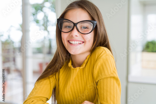 Beautiful young girl kid wearing glasses with a happy and cool smile on face. Lucky person.