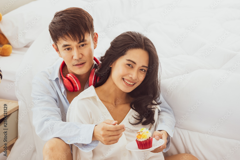 Asian couple sitting on the floor in the bedroom..