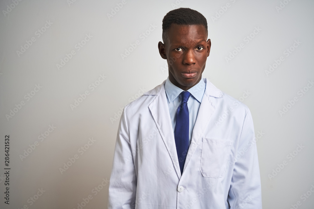 Young african american doctor man wearing coat standing over isolated white background skeptic and nervous, frowning upset because of problem. Negative person. Young african american doctor man wearing coat standing over isolated white background skeptic and nervous, frowning upset because of problem. Negative person.