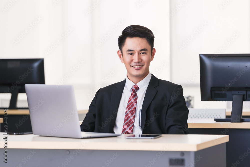 Asian businessman smiling and sittting in office,. Asian businessman smiling and sittting in office,.