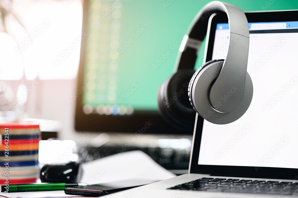 Headphones hang on laptop monitor with blank screen. Stock Photo | Adobe  Stock